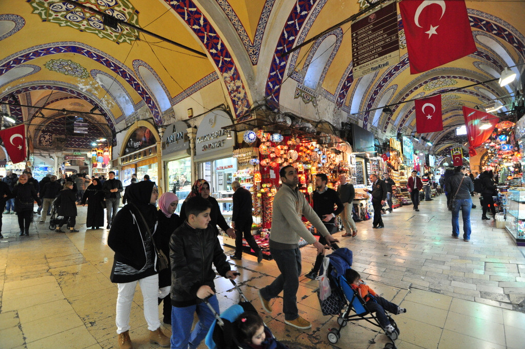 Kapalıçarşı’nın tonozlu koridorunda asılı renkli cam lambalar ve kalabalık alışveriş atmosferi